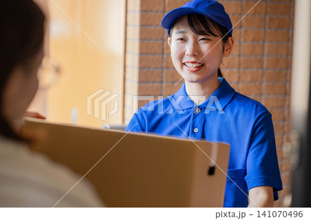 荷物を届ける宅急便の女性ドライバー 141070496