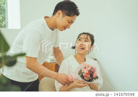 花束を受け取り喜ぶ女性と微笑む男性 花束を受け取り喜ぶ女性と微笑む男性 141070599