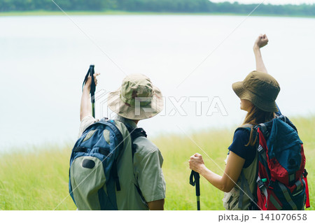 Couple hiking with backpacks near lake. Outdoor adventure and travel lifestyle. Couple hiking with backpacks near lake. Outdoor adventure and travel lifestyle. 141070658