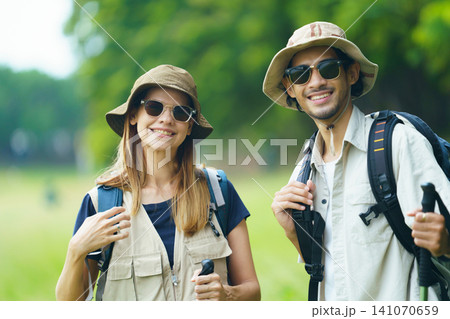 Smiling couple hiking outdoors with backpacks. Adventure travel and outdoor lifestyle in nature. Smiling couple hiking outdoors with backpacks. Adventure travel and outdoor lifestyle in nature. 141070659