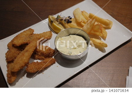Crispy fried fish and golden french fries are served with a side of creamy tartar sauce Crispy fried fish and golden french fries are served with a side of creamy tartar sauce 141071634