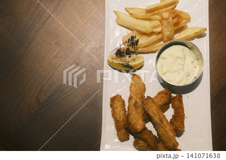 Crispy fried fish and golden french fries are served with a fresh lemon wedge 141071638