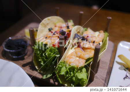 Two soft tacos feature juicy shrimp, crisp lettuce, and creamy sauce Two soft tacos feature juicy shrimp, crisp lettuce, and creamy sauce 141071644