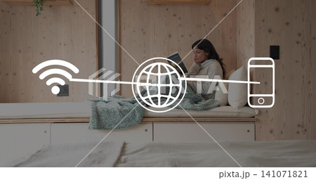 Sitting woman in sweater reading book on daybed in sleeping nook, Wi-Fi globe phone, copy space Sitting woman in sweater reading book on daybed in sleeping nook, Wi-Fi globe phone, copy space 141071821