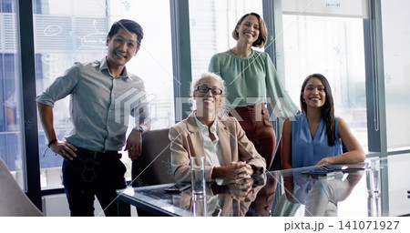 Discussing four-person group collaborating at glass table in office, in business casual with tablet 141071927
