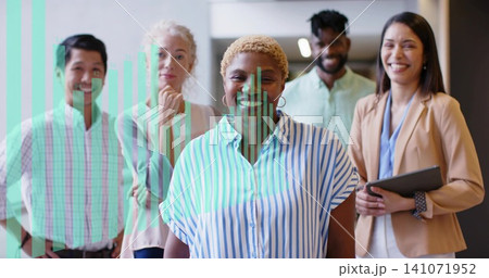 Posing central woman wearing striped shirt and tan blazer, standing in office corridor with tablet Posing central woman wearing striped shirt and tan blazer, standing in office corridor with tablet 141071952