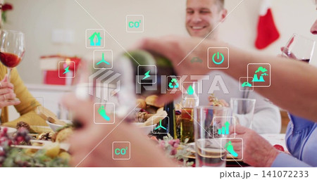 Pouring family member wearing white shirt serving wine at holiday dinner at home, with green icons Pouring family member wearing white shirt serving wine at holiday dinner at home, with green icons 141072233