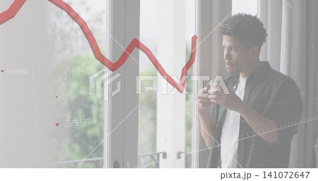 Holding mug, man wearing dark shirt gazing out glass doors at home, graph overlay, copy space Holding mug, man wearing dark shirt gazing out glass doors at home, graph overlay, copy space 141072647