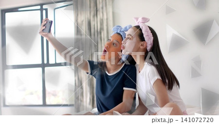 Posing teen holding phone, mom puckering on bed in navy white tees, bunny headbands and masks Posing teen holding phone, mom puckering on bed in navy white tees, bunny headbands and masks 141072720