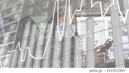 Holding phone, woman with surgical mask, jacket viewing stock charts in vehicle, with data overlay Holding phone, woman with surgical mask, jacket viewing stock charts in vehicle, with data overlay 141072947