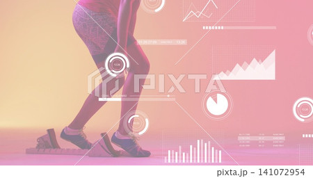 Preparing sprinter crouching in starting blocks at studio, in fitted top, shorts, spikes, HUD 141072954