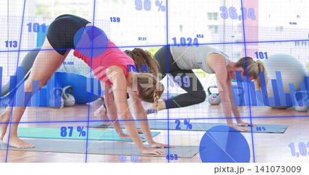 Three women in athletic wear flowing through plank-flow on yoga mats in studio with data overlay 141073009
