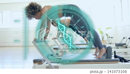 Performing three women holding plank in sportswear on reformers in Pilates studio, with teal HUD 141073108