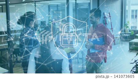 Discussing team of five in office, wearing plaid shirt, holding blue folder, showing shield-padlock Discussing team of five in office, wearing plaid shirt, holding blue folder, showing shield-padlock 141073605