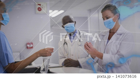 Holding spray bottle, nurse in scrubs, masked physicians in lab coats clasping at clinic desk HUD 141073616