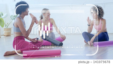 Sitting trio in athletic wear chatting in bright studio with mats, roller and HUD Sitting trio in athletic wear chatting in bright studio with mats, roller and HUD 141073678