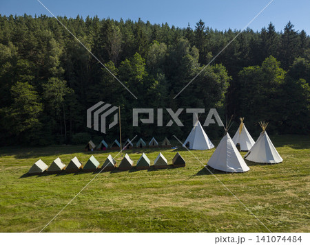 Scout camp with teepees and camping tents near forest Scout camp with teepees and camping tents near forest 141074484