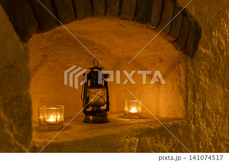 Warm light illuminating alcove with vintage lantern and candles 141074517