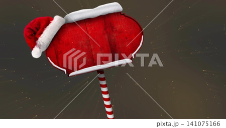 Showing red wooden signboard with white trim and Santa hat in studio, striped pole, golden sparkles 141075166