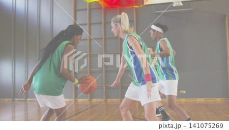 Dribbling braided dribbler driving past blue-green jerseys white shorts on court orange basketball 141075269