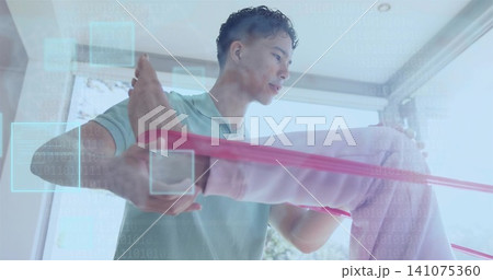 Helping therapist in green-polo guiding senior client by windows, pulling pink band with UI overlay 141075360