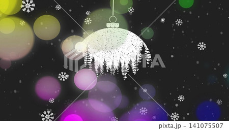 Hanging white ornament from dotted string featuring pine cutout, dark holiday background with bokeh 141075507