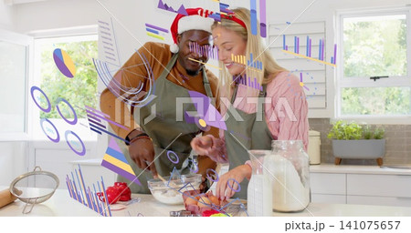 Mixing and cracking, couple in Santa hat green aprons preparing food at kitchen island AR overlays Mixing and cracking, couple in Santa hat green aprons preparing food at kitchen island AR overlays 141075657