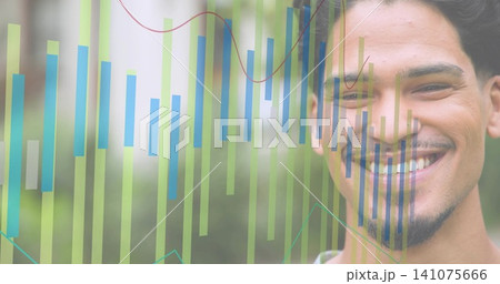 Smiling adult male wearing light shirt showing green-blue bars, line-graphs over garden, copy space Smiling adult male wearing light shirt showing green-blue bars, line-graphs over garden, copy space 141075666