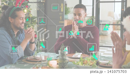 Praying center man wearing maroon sweater pressing hands at home dining table, with eco icons 141075703