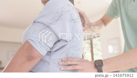 Supporting man placing hands on senior back at home, light-blue-knit-top, wireframe, smartwatch Supporting man placing hands on senior back at home, light-blue-knit-top, wireframe, smartwatch 141075912