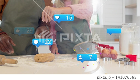 Preparing couple wearing green aprons and pink sweater kneading dough at home counter, with icons Preparing couple wearing green aprons and pink sweater kneading dough at home counter, with icons 141076365