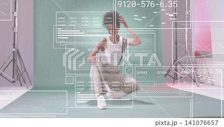 Squatting model wearing white tank top, light trousers on mint backdrop with studio lights and HUD Squatting model wearing white tank top, light trousers on mint backdrop with studio lights and HUD 141076657