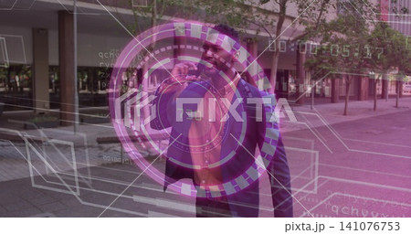 Holding smartphone near ear, adult man in business attire interacting with AR HUD at urban plaza 141076753