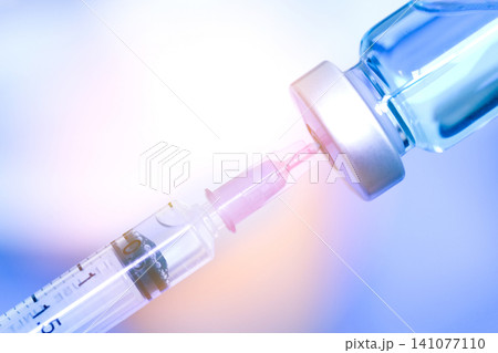 doctor's hand holds a syringe and a blue vaccine bottle at the hospital. Health and medical concepts. 141077110