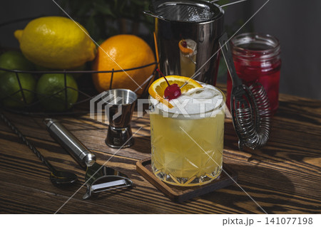 Whiskey Sour Cocktail in old fashioned glass with water drops, dark background 141077198