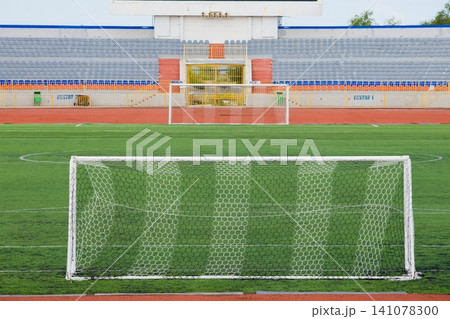 STADIUM - Football field with goal and tablo on blue sky 141078300
