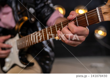 Close up of fingers on electric guitar fretboard Close up of fingers on electric guitar fretboard 141078430