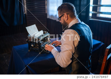 Professional author working on a typewriter Professional author working on a typewriter 141078497