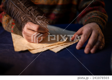 Hand of a writer writing with a feather quill Hand of a writer writing with a feather quill 141078503