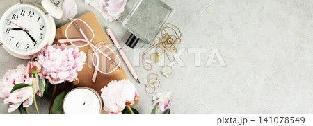 Feminine Workspace with Clock, Flowers, and Stationery Feminine Workspace with Clock, Flowers, and Stationery 141078549