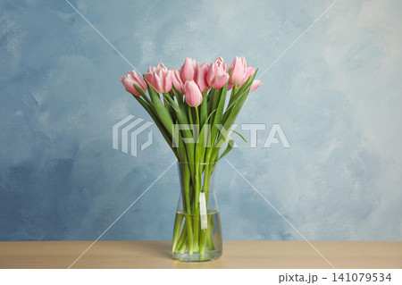 Beautiful pink spring tulips in vase on wooden table Beautiful pink spring tulips in vase on wooden table 141079534