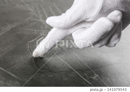 Person in white glove checking cleanliness of grey stone table, closeup Person in white glove checking cleanliness of grey stone table, closeup 141079543