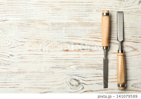 Chisels on white wooden background, flat lay with space for text. Carpenter's tools Chisels on white wooden background, flat lay with space for text. Carpenter's tools 141079589