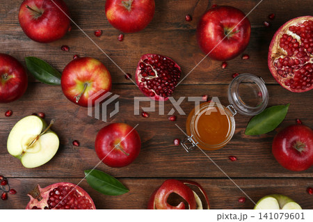 Honey, apples and pomegranate on wooden table, flat lay. Rosh Hashanah holiday Honey, apples and pomegranate on wooden table, flat lay. Rosh Hashanah holiday 141079601