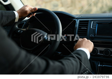 Professional driver in luxury car, closeup. Chauffeur service Professional driver in luxury car, closeup. Chauffeur service 141079736