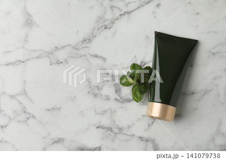 Cosmetic product and mint on white marble table, flat lay. Space for text Cosmetic product and mint on white marble table, flat lay. Space for text 141079738