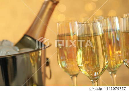 Glasses of champagne against blurred lights, closeup Glasses of champagne against blurred lights, closeup 141079777