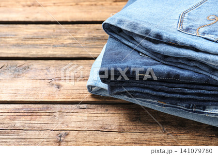 Collection of stylish jeans on wooden background, closeup. Space for text 141079780