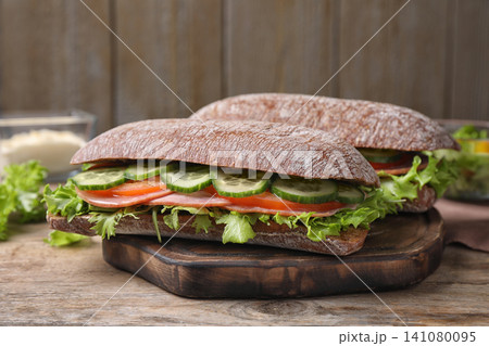 Tasty sandwiches with ham on wooden table Tasty sandwiches with ham on wooden table 141080095