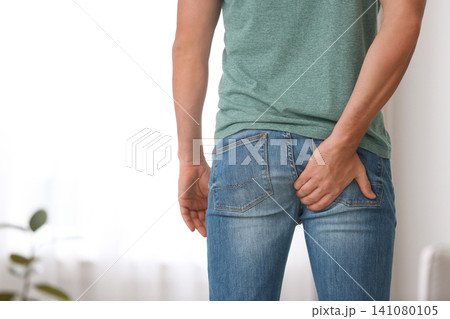 Man suffering from hemorrhoid at home, closeup 141080105